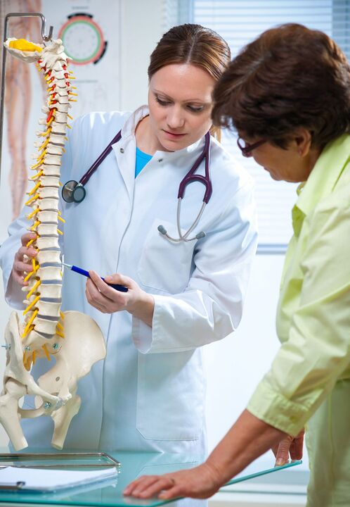 the doctor shows osteochondrosis of the spine on a model